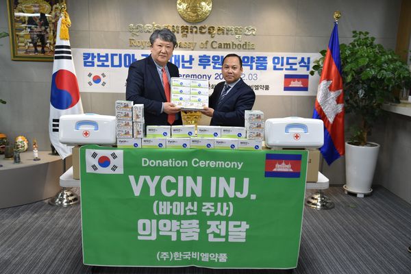 한국비엘약품 노충환 대표가 롱 디멍 주한 캄보디아 대사에게 의약품을 전달하는 모습.